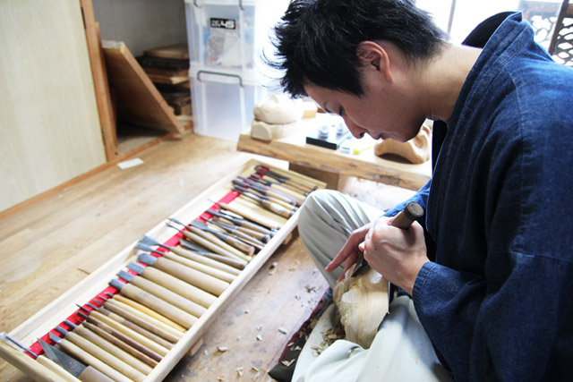 A traditional craftsman is carving Takachiho Kagura Masks.