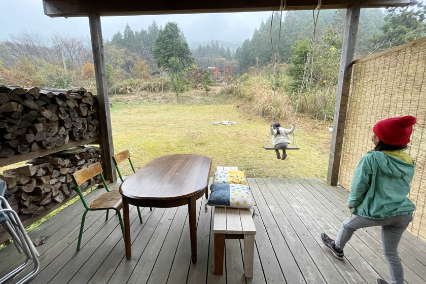 Two children are playing on a swing on the terrace of a cafe in rural Japan.