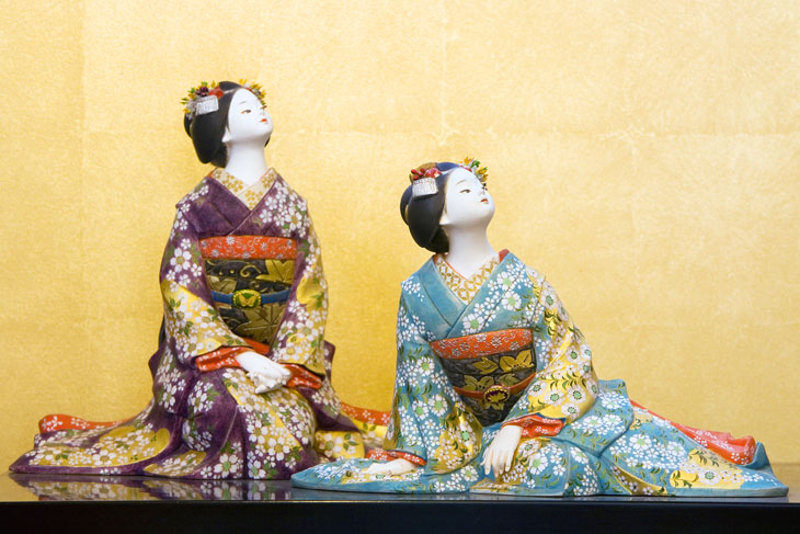 This is a picture of a Hakata doll with two women wearing colorful kimonos.