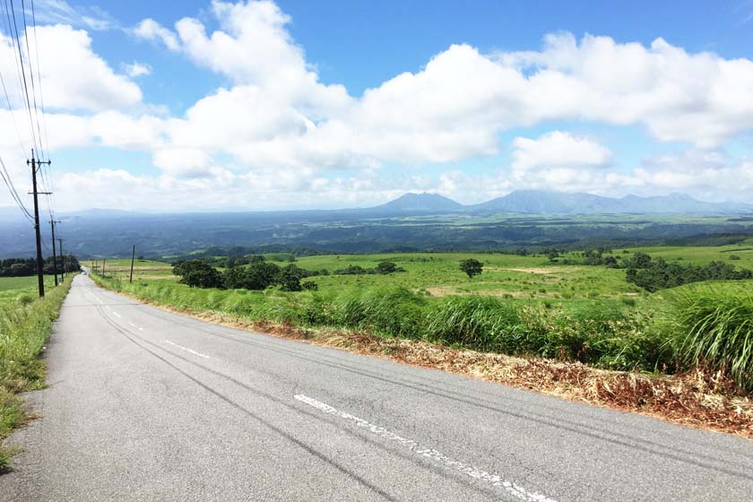 A straight road with a view of Mt. Aso from Kuju Highland.