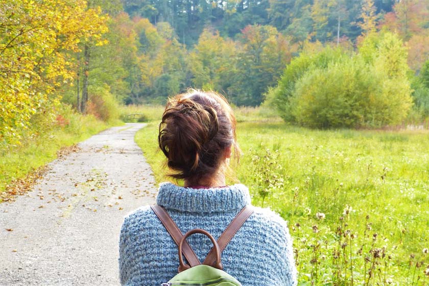 A woman traveling alone in Japan takes a pleasant stroll through a beautiful forest.